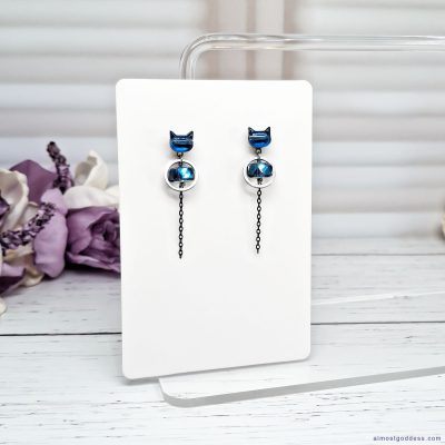 Blue cat dangle earrings with stainless steel silver circle charm and black chain. Cute animal stud earrings for women on white display card